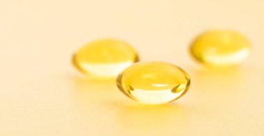 Altın arka planda balık yağı takviyesi kapsülleri. Kozmetik, omega 3 altın baloncuk. Altın yağ kapsülleri. Vitamin yuvarlak hap seti.