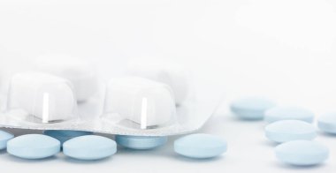 Önplanda bir sürü mavi olan beyaz haplar.