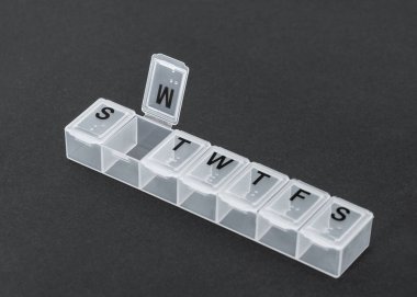 Siyah arka planda plastik hap organizatörü. O günün haplarını alma organizasyonu.