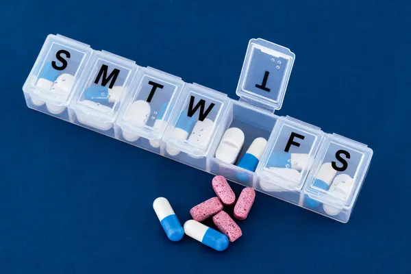 A weekly pills box, tablets, vitamins.
