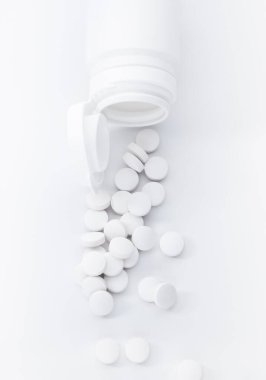 Üzerinde fotokopi alanı olan beyaz şişeden dökülen hapların üst görüntüsü. Tıbbi sağlık hizmeti kavramı