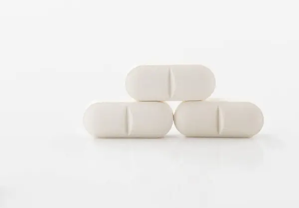 Beyaz haplar ya da kapsüller. İlaç ya da kapsül şeklinde gıda takviyeleri.