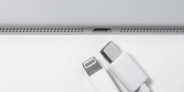 Apple Lightning 'den USB-C kablosuna ve boş bir masa üzerindeki cihaza, yakın plan. Reklam için yer var. Teknoloji konsepti.