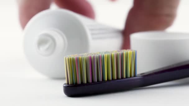 チューブ歯磨き粉と歯ブラシのクローズアップ 選択的な焦点 デイリー歯科医療コンセプト — ストック動画