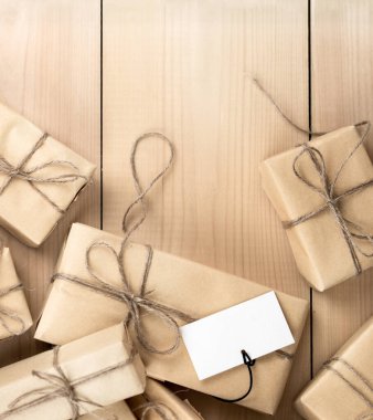 Kahverengi Geri Dönüşümlü Kağıt 'a sarılmış Hediye Kutuları Tahta Masa Tebrik Edildi. Boşluk ve Tatil Konseptini Kopyala