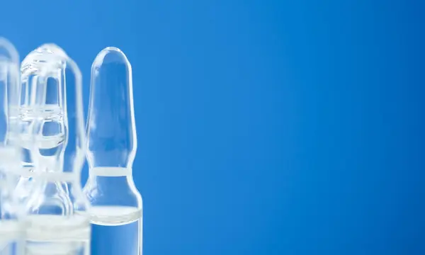 Ampoules with medicine on a blue background. The concept of medicine and immunity. Copy space.