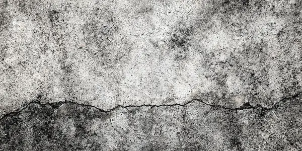 Fractured concrete wall or floor. Damaged wall background. Gray grunge cement surface with large cracks.