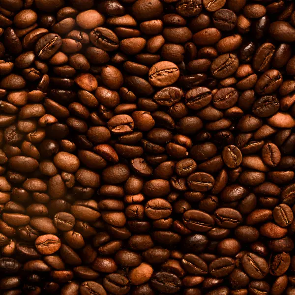 Fresh Roasted Coffee Beans in a pile close-up. Coffee background. Top view of freshly roasted coffee beans