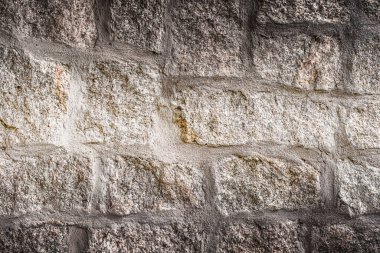 Old stone wall background. Closeup front view of dark stone wall texture