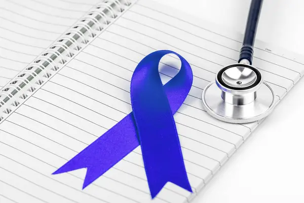 Dünya Kanser Günü kartı. Doktor masasında kurdele olan kanser farkındalığı konsepti
