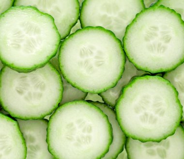 Taze yeşil salatalık dilimleri arka planda. Üst görünüm