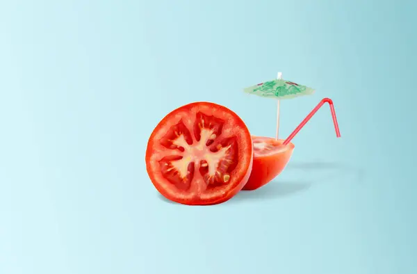 Tomato cocktail with straw and sun umbrella on light blue gradient background. Minimal summer tropical beach concept