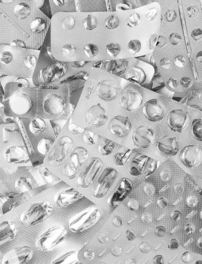 Bir yığın kullanılmış gümüş kabarcık. Boş ilaç paketleri var. Tıp geçmişi desteler. Tedavi ve ilaç konsepti