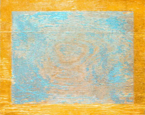 Worn blue paint on old wood plank with gold edge frame. Shabby plank with cracks and stains
