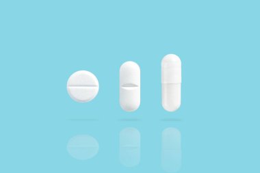 Various white medicine pills levitate over a blue background. Shadow and reflection from drugs. clipart