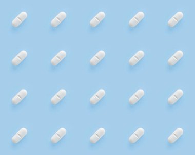 White pills capsules on blue background. Seamless repetitive pills. clipart