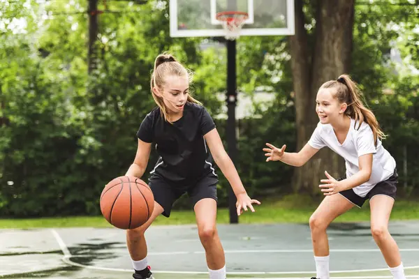 stock image the two girl child in sportswear playing basketball game