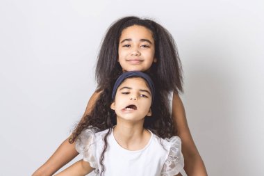 An Adorable 9 years child girl on studio white background with her sister clipart