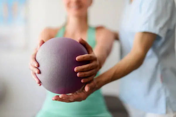 stock image A Modern rehabilitation physiotherapy woman worker with woman client using ball