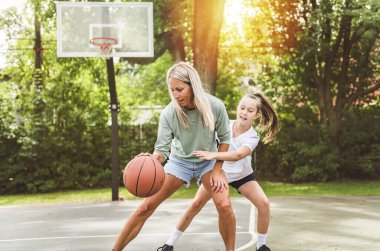 Mother and little daughter after basketball. Great job honey. clipart