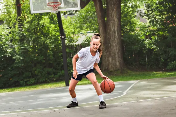 Stock image A girl with basketball on court on summer season