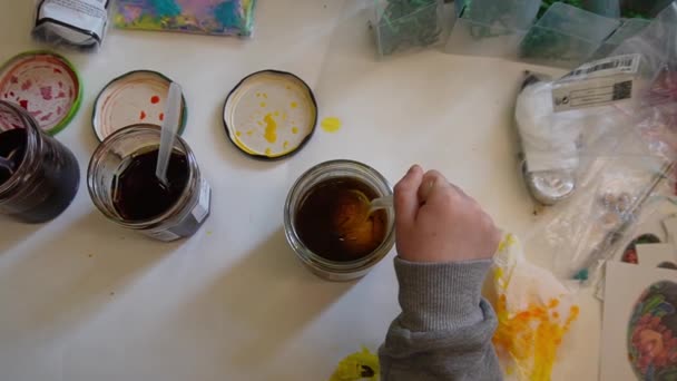 イースターエッグに染まる子供 子供が卵を黄色い染料の瓶に浸すワックス抵抗技術を使用して卵を飾るプロセス — ストック動画