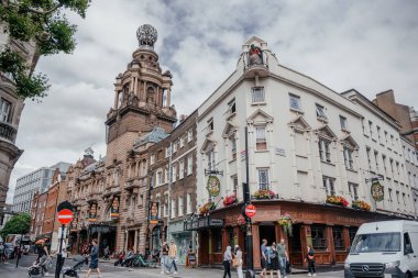 Tarihi Viktorya dönemi binaları, yayalar ve modern ve geleneksel şehir unsurlarının karışımının yer aldığı işlek bir Londra kavşağı.
