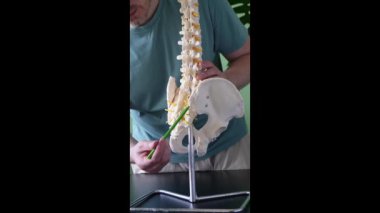 Bir tıp uzmanı, PSIS 'in anatomisini ve işlevini açıklamak için omurga modeli kullanır.