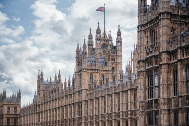 İngiliz Parlamentosu 'na ev sahipliği yapan Westminster Sarayı Thames Nehri boyunca görkemli bir şekilde duruyor ve ikonik Gotik mimarisini gözler önüne seriyor.