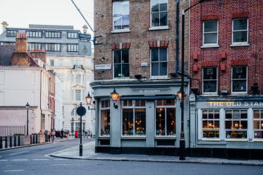 Westminster, Londra 'da büyüleyici bir sokak köşesi. Tarihi tuğla binalar, geleneksel barlar ve öğleden sonra sakin bir şehir atmosferi var.
