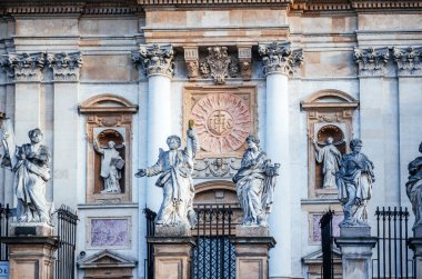 Krakow 'daki Barok kilise cephesinin ayrıntılı bir görüntüsü, karmaşık taş heykeller, süslü sütunlar ve dini oymalar, tarihi Avrupa mimarisinin sergilendiği