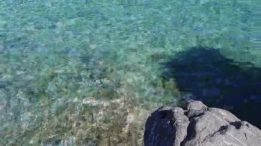 Sicilya 'daki Capo Gallo Doğa Rezervi' nde kayaların üzerinde hareket eden kristal berrak Akdeniz sularının rahatlatıcı bir videosu, dinlenme ve meditasyon için ideal.