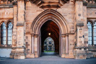 Glasgow Üniversitesi 'nin taş kemerli girişi, iç avluya bakışıyla eğitim, tarih ve Gotik mimari için ideal.