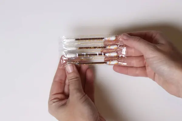 Beyaz arka planda paketli çubukları tutan eller