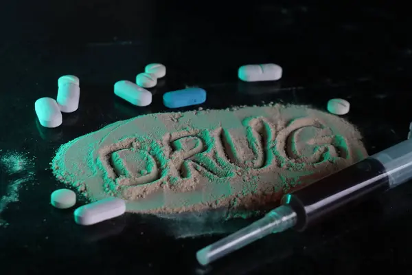 Uyuşturucu tozunun yanında şırınga ve haplar