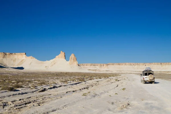 Stock image Offroad vehicle in Bozzhira valley, adventure travel, Kazakhstan. Rock pinnacles formations