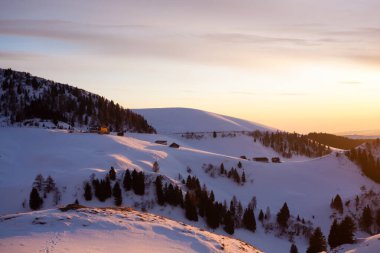Gün batımında dağlarda, ön planda barınak var. İtalyan Alpleri