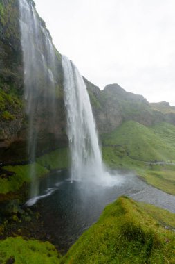 Seljalandsfoss yaz sezonunda İzlanda 'ya düşer. İzlanda manzarası.