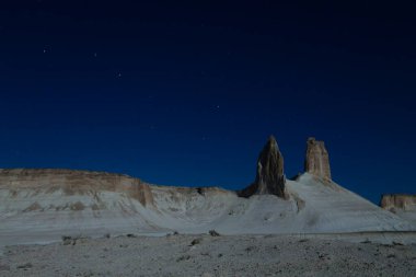 Night scene with the rock pinnacles of Bozzhira valley, Kazakhstan. Ursa major constellation clipart