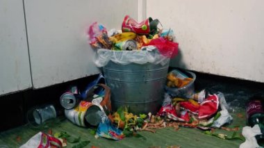 Dolu çöp tenekesi olan dağınık mutfak