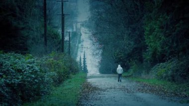 Yağmurlu bir günde Adam Şehir Parkında Yürüyor