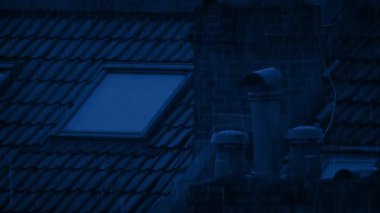 Yağmurlu bir gecede tavan arasında ışık yanar