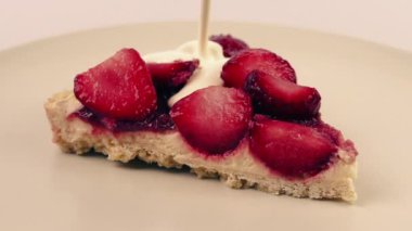 Çilekli kekin üstüne krema döküldü.