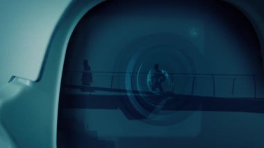 Güvenlik kamerası, yaya köprüsünde yürüyen insanları yansıtıyor.