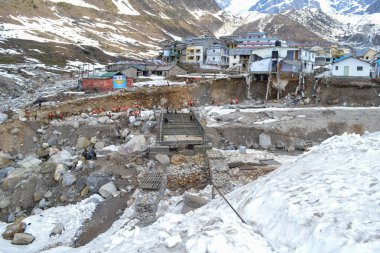 Kedarnath faciasında çöken inşaat köprüsü altında. Kedarnath tapınağı bölgesi için bir yeniden yapılanma planı var. Hasar görmüş ve 2013 sel baskınlarında önemli ölçüde yok olmuş.. 