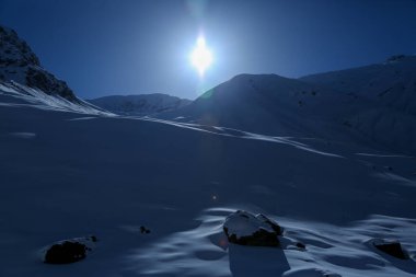 Hindistan 'da karla kaplı dağ ve güneş ışınları. Karla kaplı dağlar Hindistan 'da büyüleyici manzaralar yaratır.. 