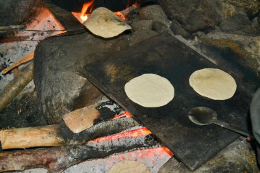 Hindistan 'da geleneksel yemek pişirme şekli. Mutfakta açık ateşte yemek hazırlıyorum. Hindistan 'ın birçok köyünde insanlar hala yiyecek üretmek için bu geleneksel kurallara uyuyorlar..