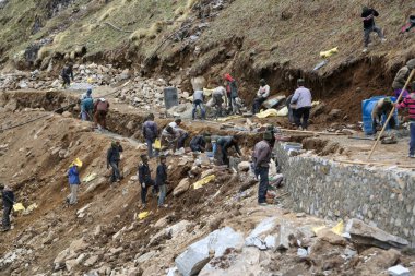 Rudarpray, Uttarakhand, Hindistan, 3 Mayıs 2014, Kedarnath faciasında hasar gören yolu yeniden inşa eden işçi. Kedarnath, Haziran 2013 'te heyelan ve ani sel felaketleri sonucu yıkıldı.