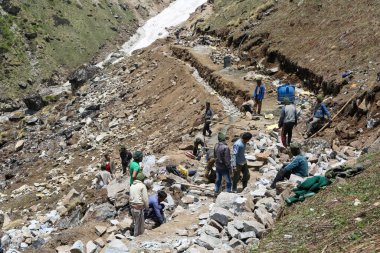 Rudarpray, Uttarakhand, Hindistan, 3 Mayıs 2014, Kedarnath faciasında hasar gören yolu yeniden inşa eden işçi. Kedarnath, Haziran 2013 'te heyelan ve ani sel felaketleri sonucu yıkıldı.