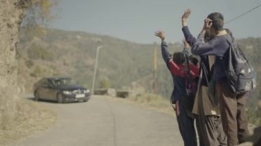 Bulaşıcı neşe ile, sevimli Hintli okul çocukları neşeyle bir arabaya durması için işaret vererek, genç 45 'lik görüntülerle dolu yürek ısıtan bir yol kenarı sahnesi yaratıyorlar.